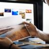 Mann betrachtet Foto neben Computer - zur Veranschaulichung der Google Bildersuche