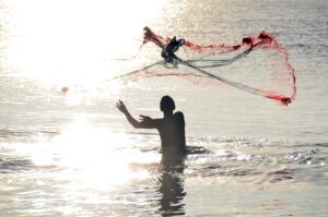 Mensch im Meer mit Fischernetz