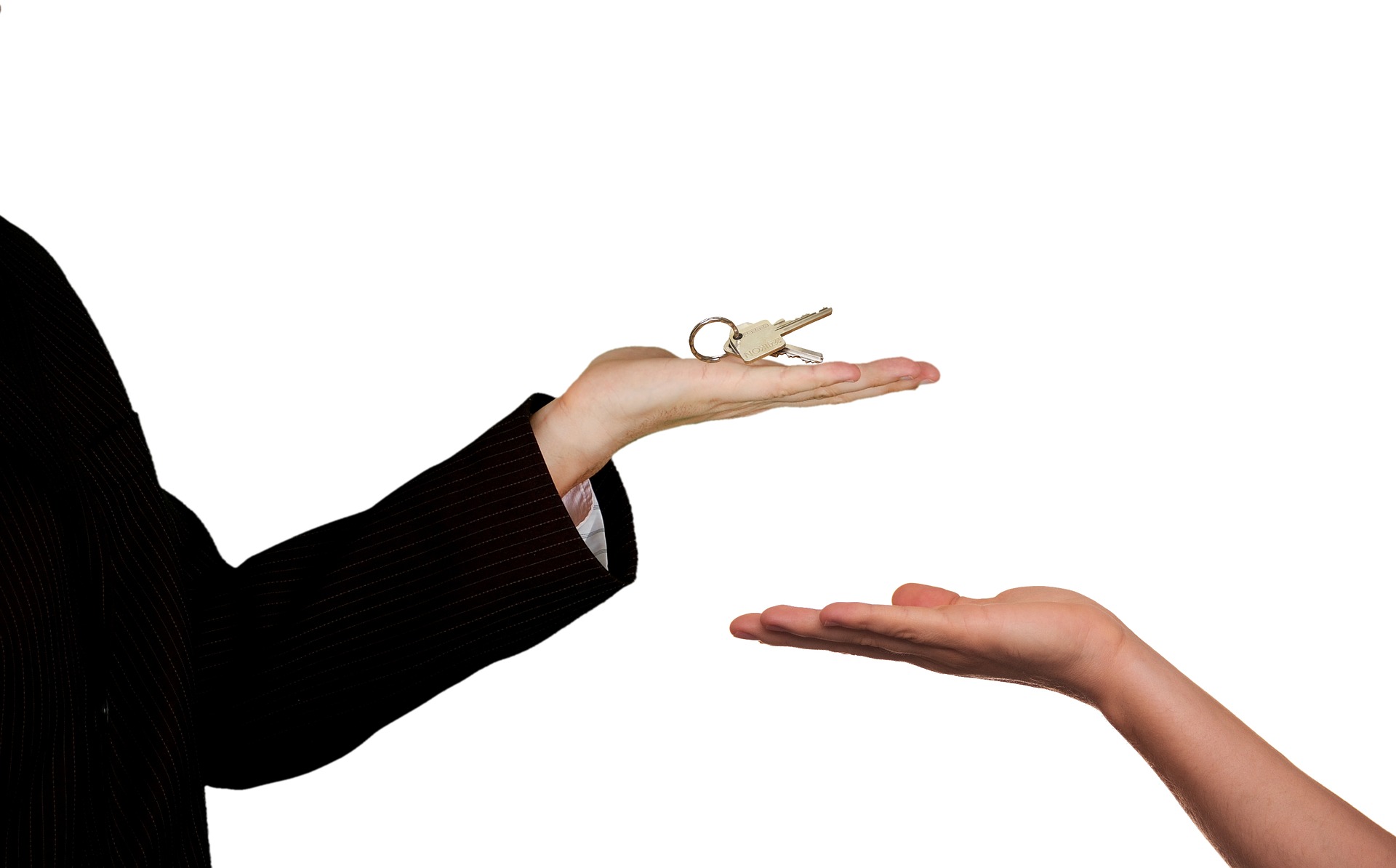 Eine Hand mit Schlüssel in der Hand und dadrunter eine weitere Hand die den Schlüssel entgegen nehmen will. Es geht um die Vermietung oder den Verkauf einer Immobilie.