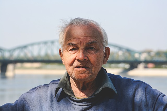 Älterer Mann vor Brücke und Fluss