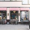 drei bemalte Schaufenster mit weiß-roten Markisen