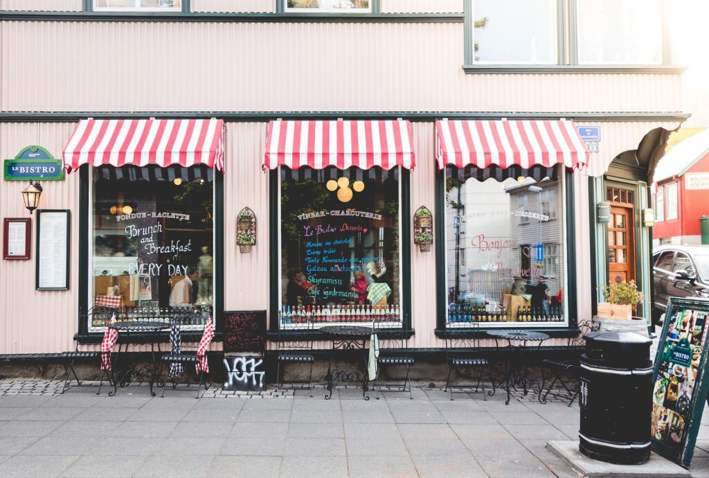 drei bemalte Schaufenster mit weiß-roten Markisen