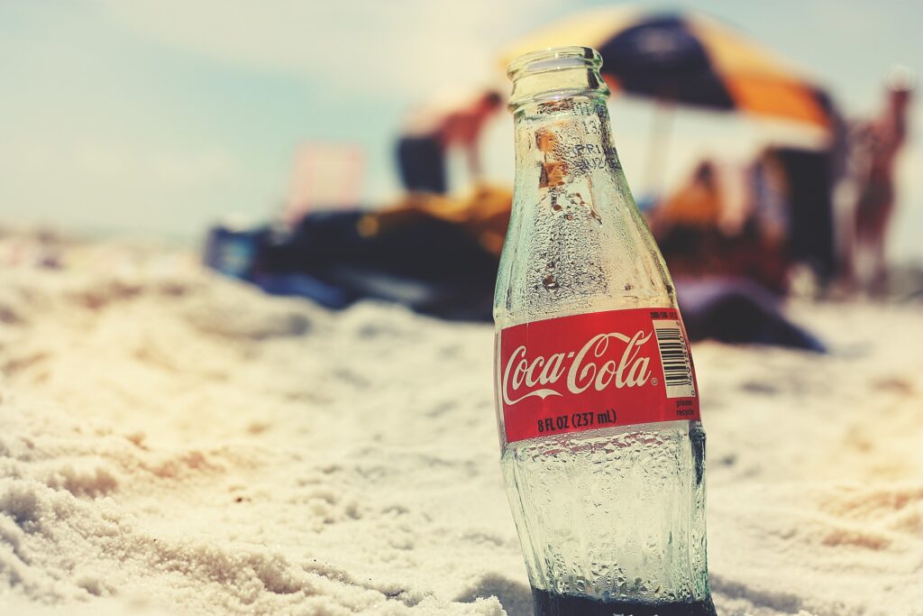 Cola Flasche im Vordergrund, im Hintergrund Strand zur Verdeutlichung des Blogbeitrages Product Placement