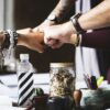 5 Fäuste über Tisch mit Büromaterialien