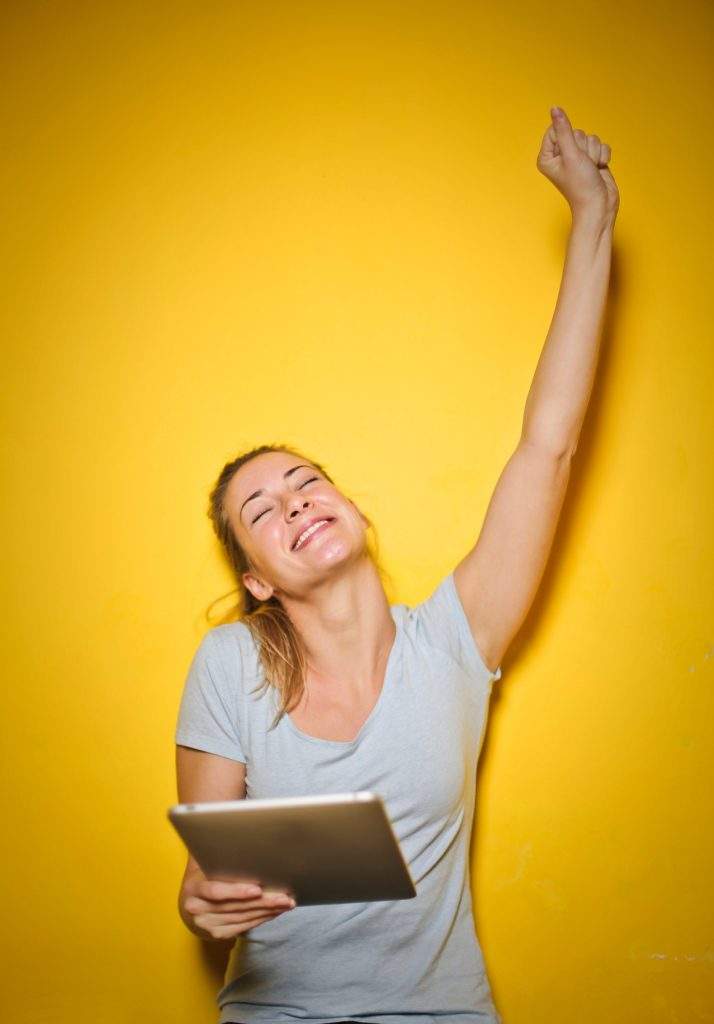 Glückliche Frau mit Tablet in der Hand