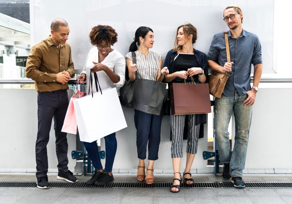 Mit glückliche Leute mit Shoppingtüten vor weißer Wand