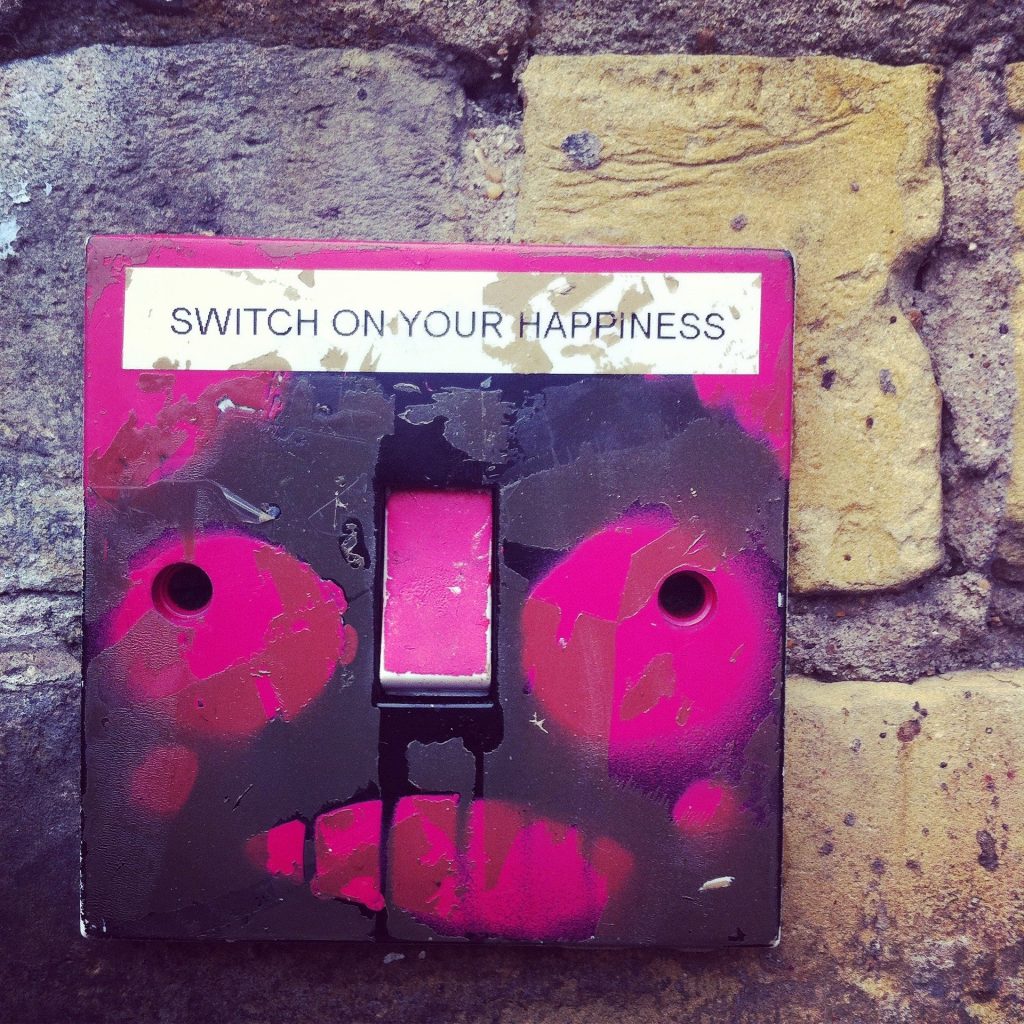 Pinker Kasten mit der Aufforderung "Switch on your Happiness"