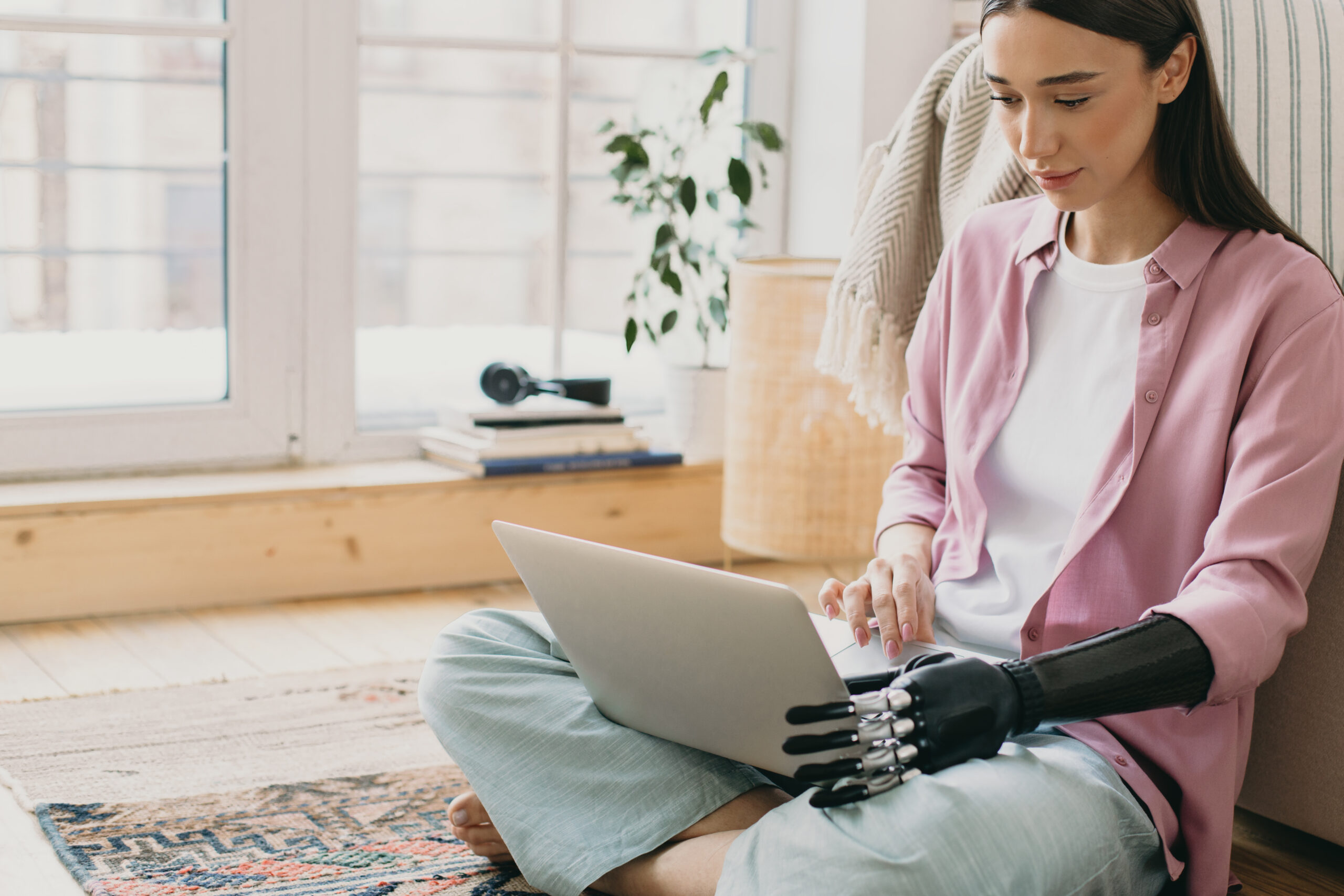 Frau mit Armprothese arbeitet am Laptop