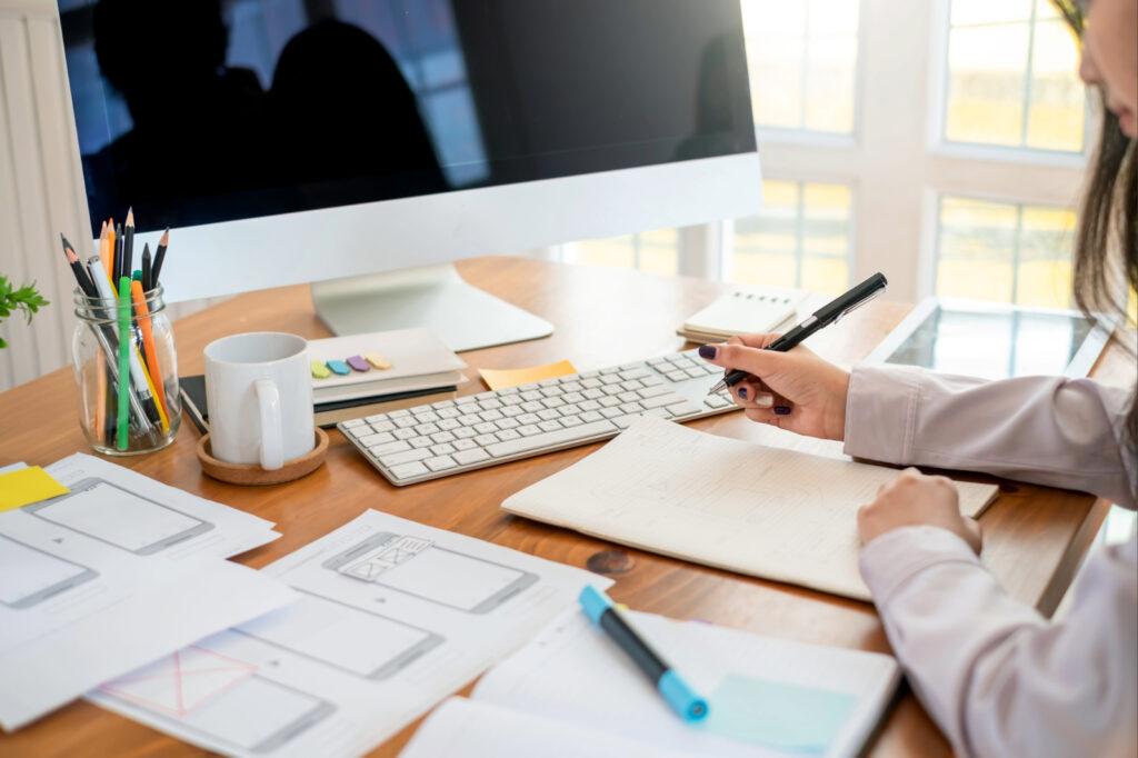 Frau am Schreibtisch arbeitet an einer Website.