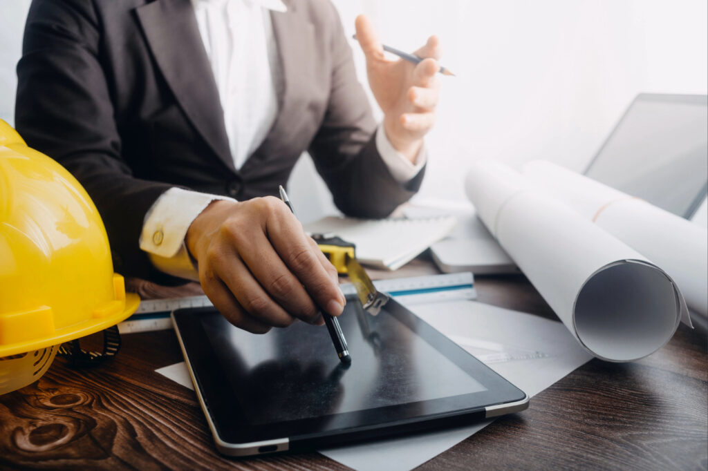Digitales Marketing für Handwerksbetriebe mit Tablet, Bauplänen und Laptop.