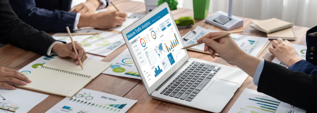 Team analysiert Website-Traffic und Performance-Daten auf einem Laptop